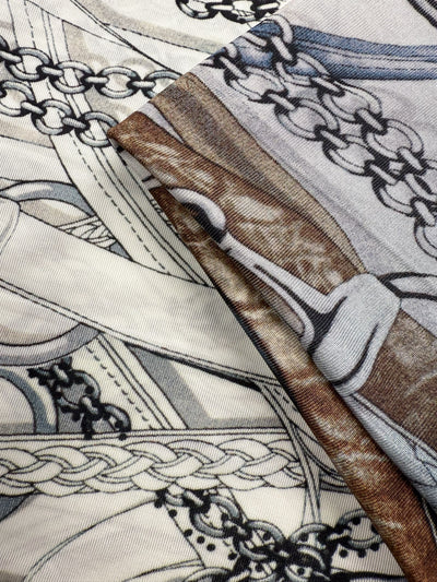 Close-up of Super Cheap Fabrics' Viscose Knit - Link (138cm), showcasing two pieces with intricate equestrian-themed patterns—interwoven chains, ropes, and stirrups in cream, gray, black, and brown.