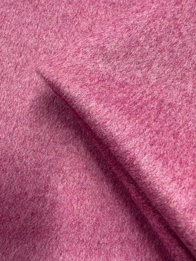 Close-up of Wool Cashmere - Wild Rose by Super Cheap Fabrics (150cm), showing its soft, medium to heavy weight texture in a vivid pink shade, with one edge folded to highlight the even color and fuzzy wool surface.