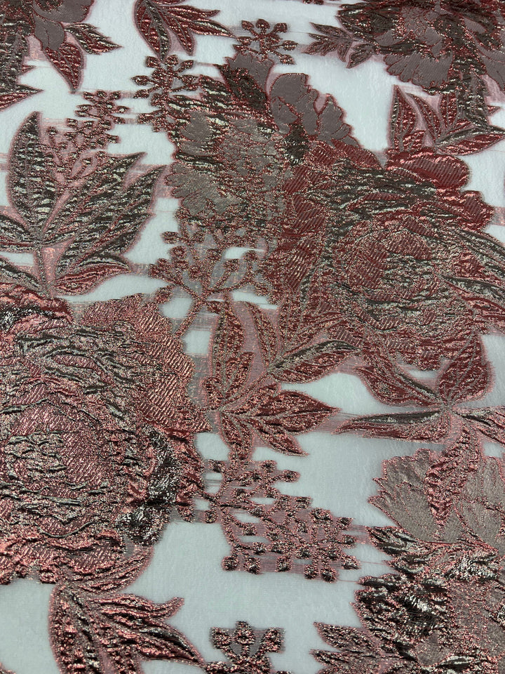 The Designer Metallic Brocade - Anne from Super Cheap Fabrics showcases intricate rose gold floral embroidery with leaves and flowers on a sheer white polyamide background, resulting in a textured and elegant pattern. The fabric measures 160cm wide.