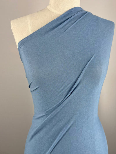 A mannequin displays a graceful one-shoulder dress in Blissful Blue against a gray backdrop. Made with Super Cheap Fabrics' Summer Cotton Knit, it offers a smooth, slightly fitted look and excellent stretch recovery.