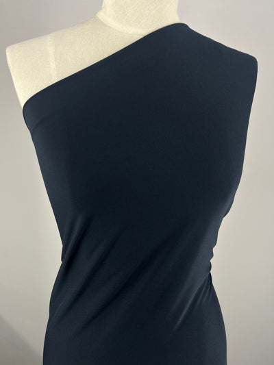 A mannequin draped in the sleek, navy-colored Double Knit Jersey from Super Cheap Fabrics, featuring an asymmetrical one-shoulder design against a plain background.