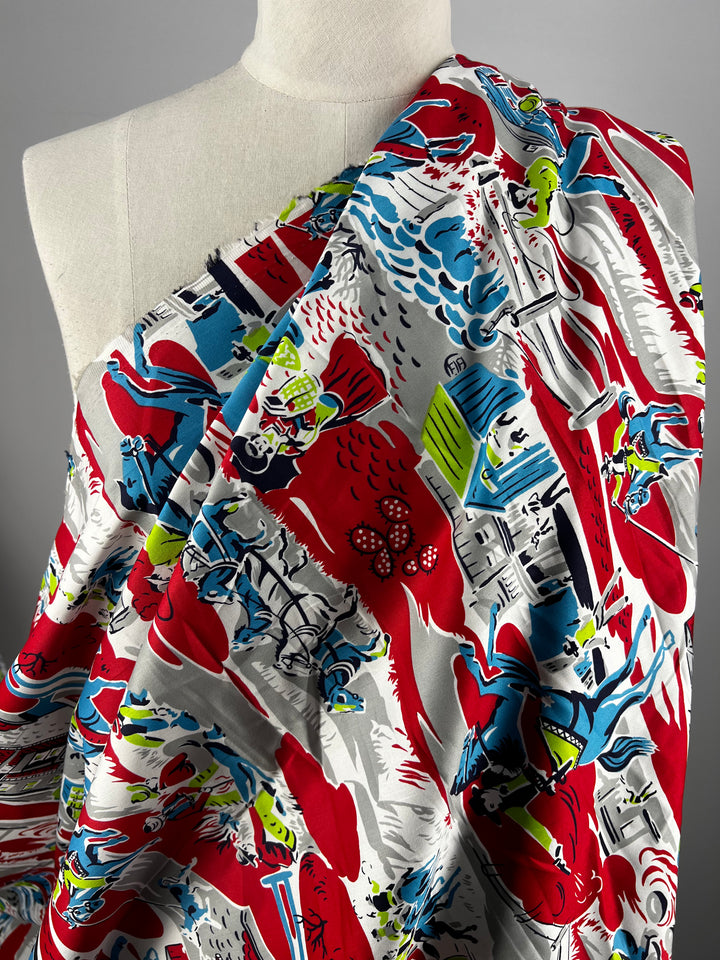 A mannequin adorned with Super Cheap Fabrics' Cotton Sateen - Red Western - 150cm, showcasing a vibrant and colorful print of emergency vehicles, firefighters, and flames. The fabric vividly portrays an action-packed rescue scene in bold shades of red, blue, green, and white.