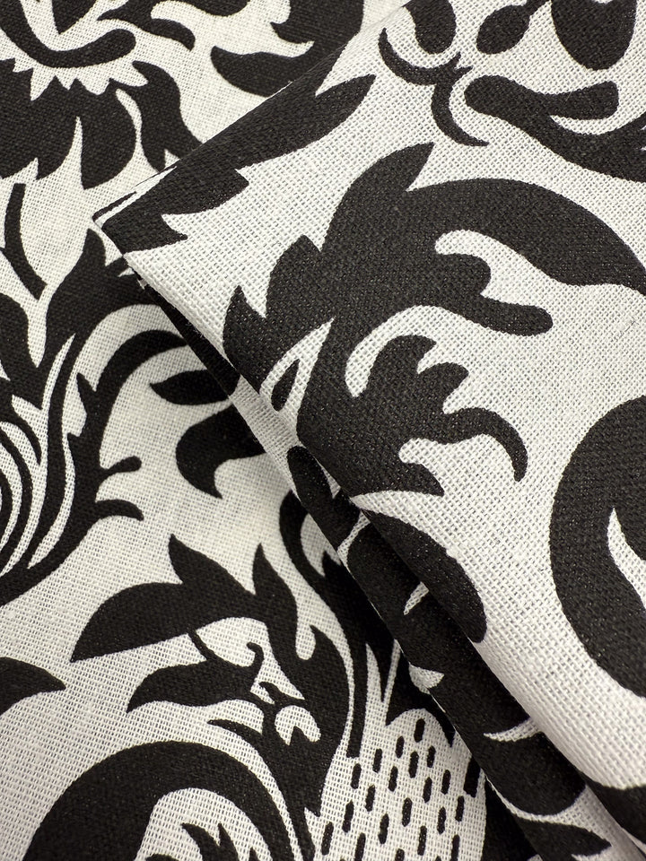 Close-up of the Printed Linen Blend - Baroque Noir (145cm) by Super Cheap Fabrics, featuring an ornate black and white floral damask pattern—ideal for elegant summer jackets.