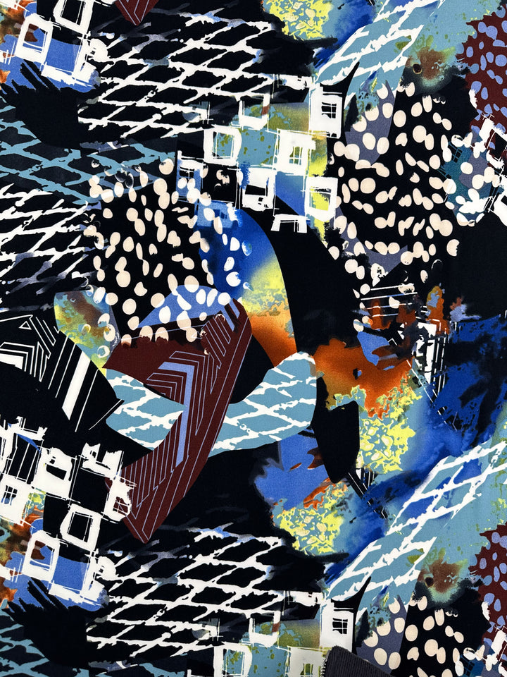 A vibrant, abstract painting featuring a chaotic mix of shapes and colors. The composition includes swirling white lines, blocky geometric forms, splatters of dots, and bold strokes of blue, black, orange, and green—much like the dynamic patterns you might find on Super Cheap Fabrics' Printed Lycra - Tonal - 150cm—creating an energetic visual.