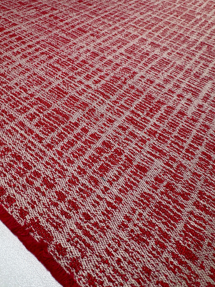 A close-up of Upholstery - Dexter 35 by Super Cheap Fabrics reveals a red and white textured abstract pattern. This heavy-weight polyester design, with dynamic vertical and horizontal elements, adds an irregular look ideal for Montpellier 26 furnishings.