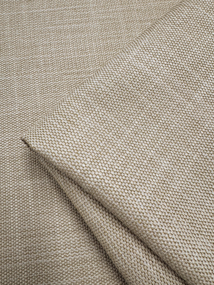 Close-up of folded Upholstery - Rhodes Natural by Super Cheap Fabrics, featuring a beige textured fabric with a subtle dotted pattern, showcasing its weave and soft texture, perfect for adding elegance to any space.