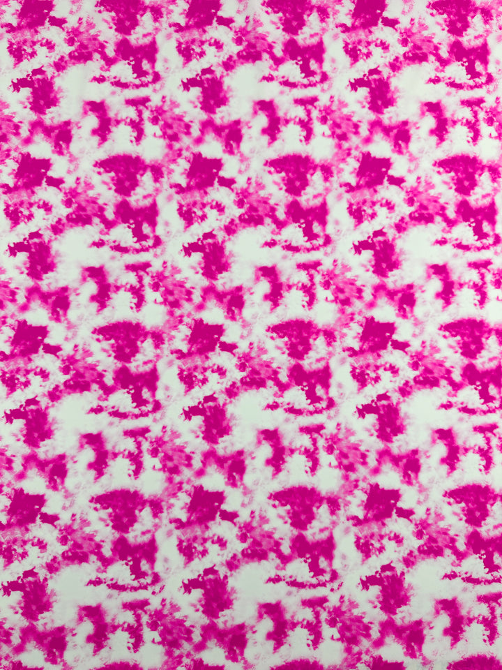 The Printed Nylon Lycra - Bandhani - 155cm from Super Cheap Fabrics showcases a vibrant pattern featuring an abstract design in shades of pink and white. The pink areas form cloud-like shapes, evenly distributed throughout the fabric, creating a dynamic and lively appearance. This lightweight material is ideal for multi-use clothing, ensuring both comfort and style.