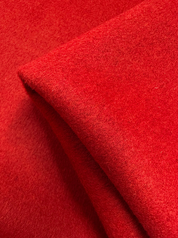 A close-up of Super Cheap Fabrics’ Wool Cashmere - Lava Falls - 150cm shows its bright red color, thick and smooth surface, luxurious softness, fuzzy texture, and comfort suitable for year-round use.