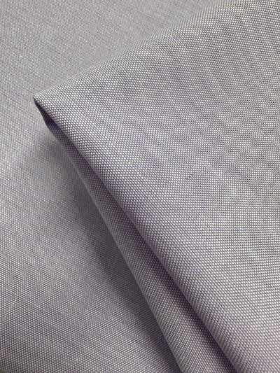 Close-up of folded Oxford Cotton in Baby Lavender (146cm) by Super Cheap Fabrics. The fine, tightly woven cotton appears smooth and slightly reflective with neat folds and clean edges.