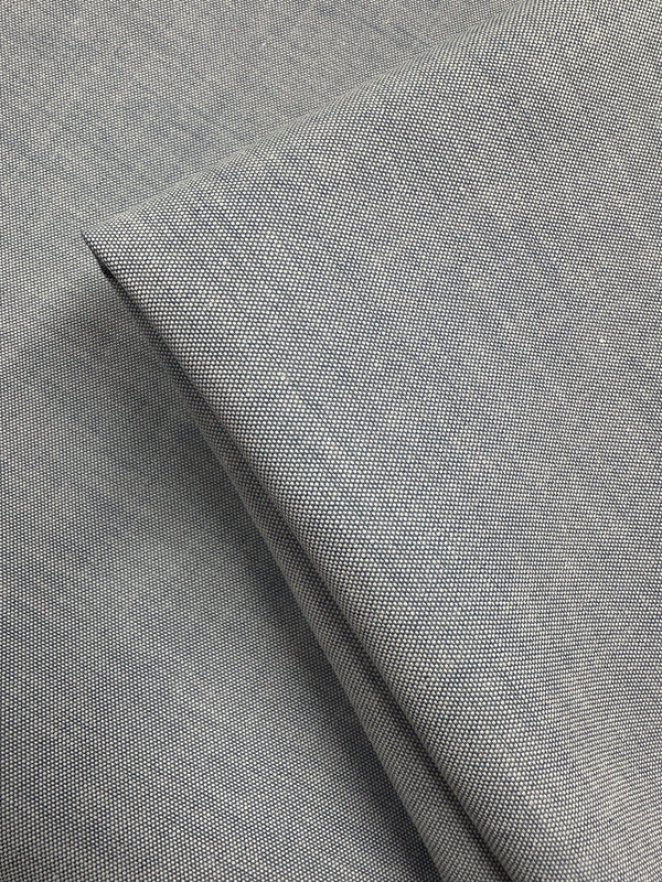 Close-up of Super Cheap Fabrics' Oxford Cotton - Denim (146cm): light gray fabric with fine woven texture, neatly folded to highlight its smooth, detailed weave and enhanced cotton softness.