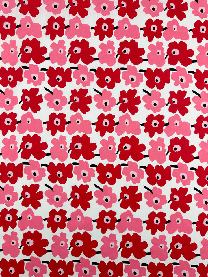 A dynamic pattern featuring bright pink and red flowers is printed on natural cotton fibers, set across a white background, creating an evenly spaced design. The design consists of simple shapes that provide a bold and playful look, making the "Printed Cotton - Little Miss Sunshine - 150cm" by Super Cheap Fabrics ideal for a variety of creative projects.