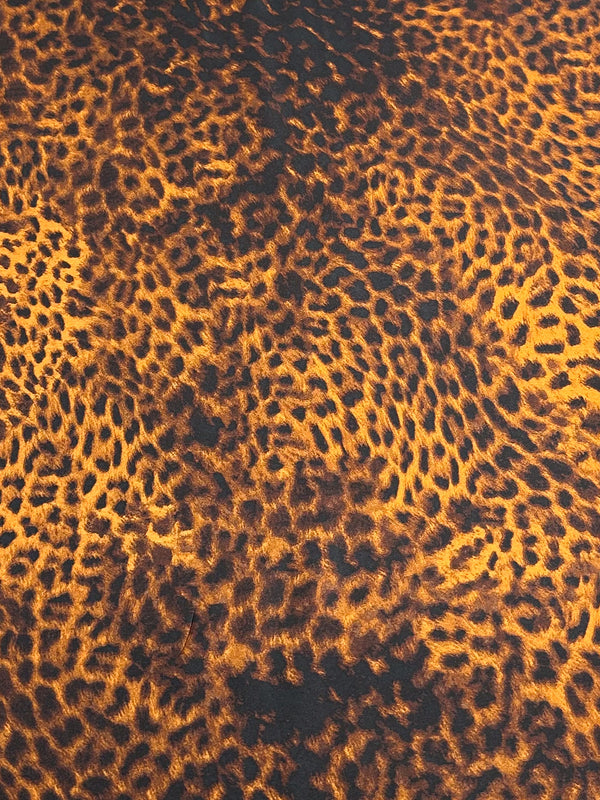 A close-up of the exquisite "Silky Satin - Namer - 145cm" fabric from Super Cheap Fabrics showcases a lively leopard print pattern of irregular black and orange spots, elegantly mimicking the natural look of a leopard's fur. The luxurious, velvety texture that resembles printed satin beautifully covers the entire image.