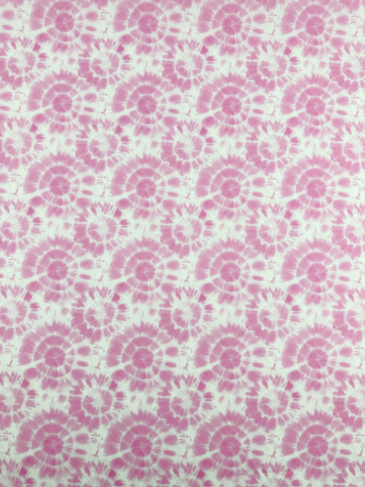 The Printed Cotton - Rosebloom - 150cm by Super Cheap Fabrics showcases a pink and white tie-dye pattern, with spiral designs elegantly spread across the natural cotton fibers, offering a striking and lively texture.