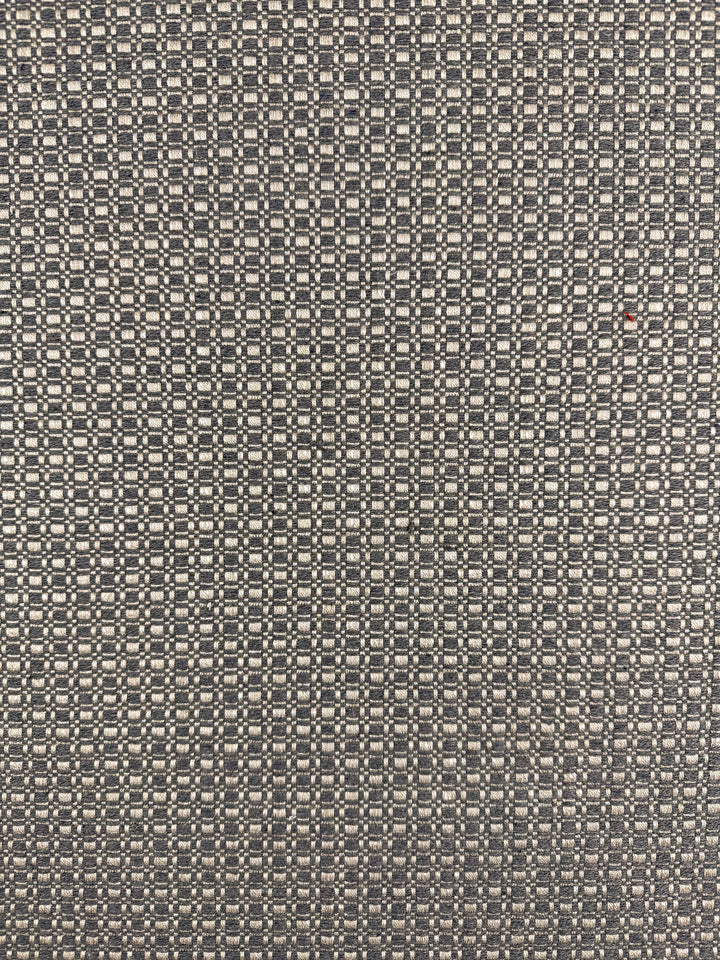 Close-up of Super Cheap Fabrics' Upholstery Basketweave - Aria Steel (144cm), showing a premium Australian fabric with a repeating geometric pattern in dark and light tones plus a small red dot—perfect for high-end upholstery projects.