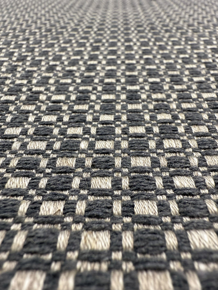Close-up of Super Cheap Fabrics’ Upholstery Basketweave - Aria Steel (144cm), an Australian premium fabric with a black and off-white checkered grid pattern—perfect for sophisticated, high-end upholstery.