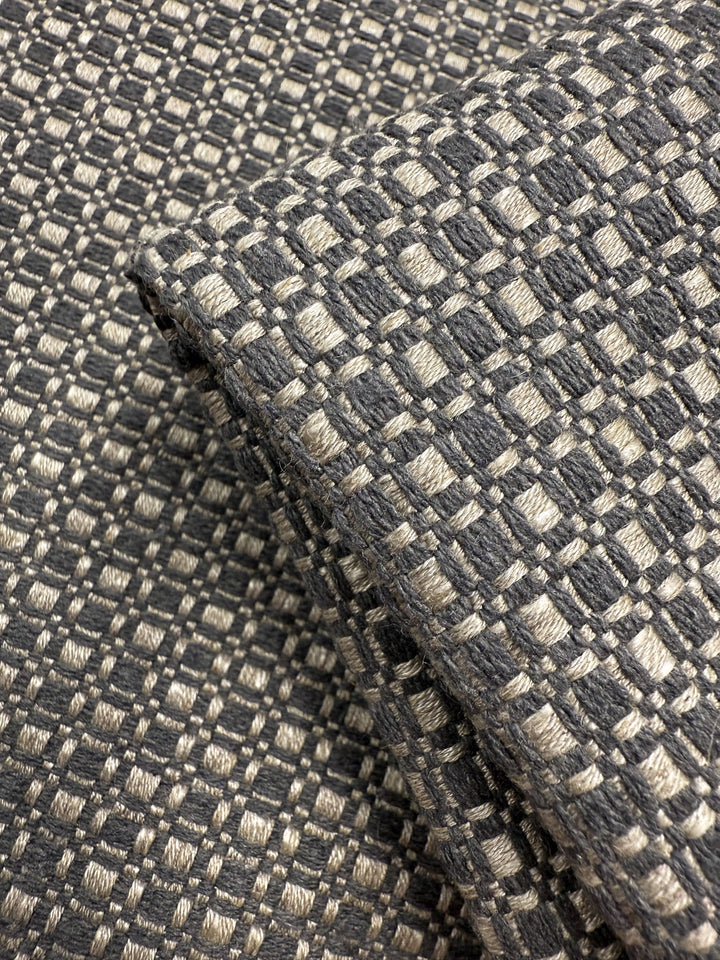 Close-up of Super Cheap Fabrics’ Upholstery Basketweave - Aria Steel (144cm): premium Australian fabric with a soft, thick feel and a textured checkerboard pattern in gray and beige featuring a raised, grid-like design.