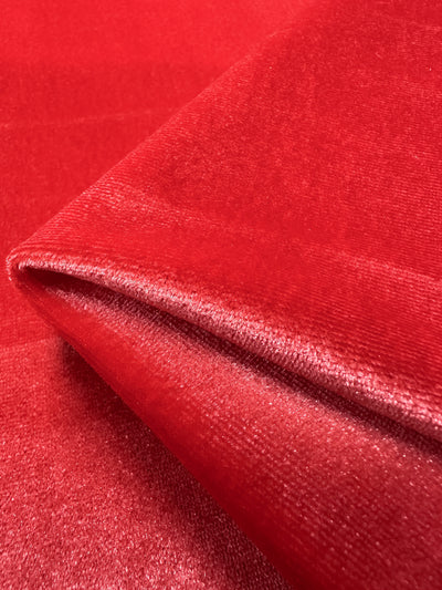 Close-up of folded Rose of Sharon Stretch Velour by Super Cheap Fabrics, highlighting the texture and sheen of this plush spandex blend. Its smooth surface appears rich and vibrant. Width: 170cm.