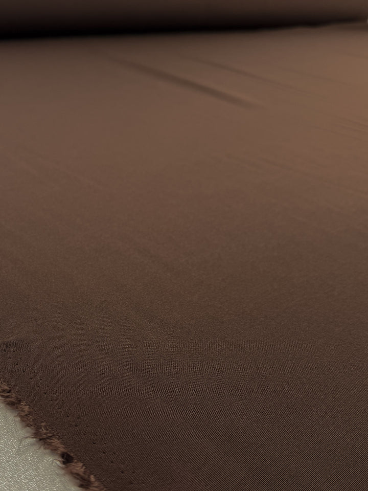 A close-up of Super Cheap Fabrics' Cotton Bengaline - Mocha Earth (150cm) shows the texture and weave of this medium weight fabric laid flat.