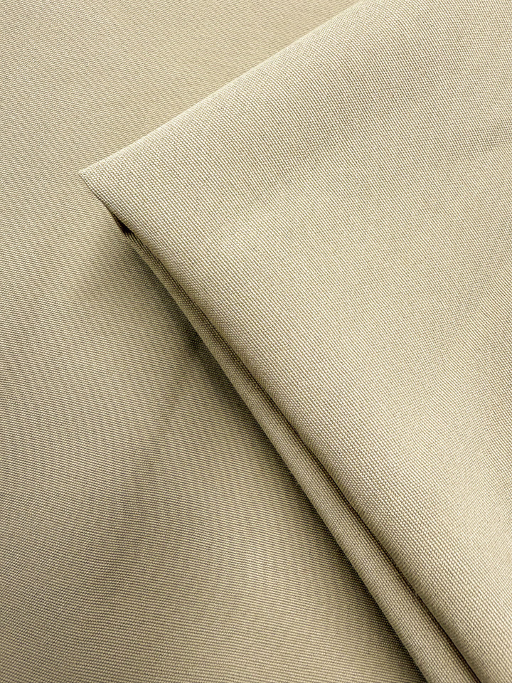 A close-up of two overlapping pieces of Super Cheap Fabrics’ Cotton Bengaline - Sand Drift (150cm), showing its medium weight, fine textured weave, subtle diagonal lines, and smooth, slightly reflective surface.