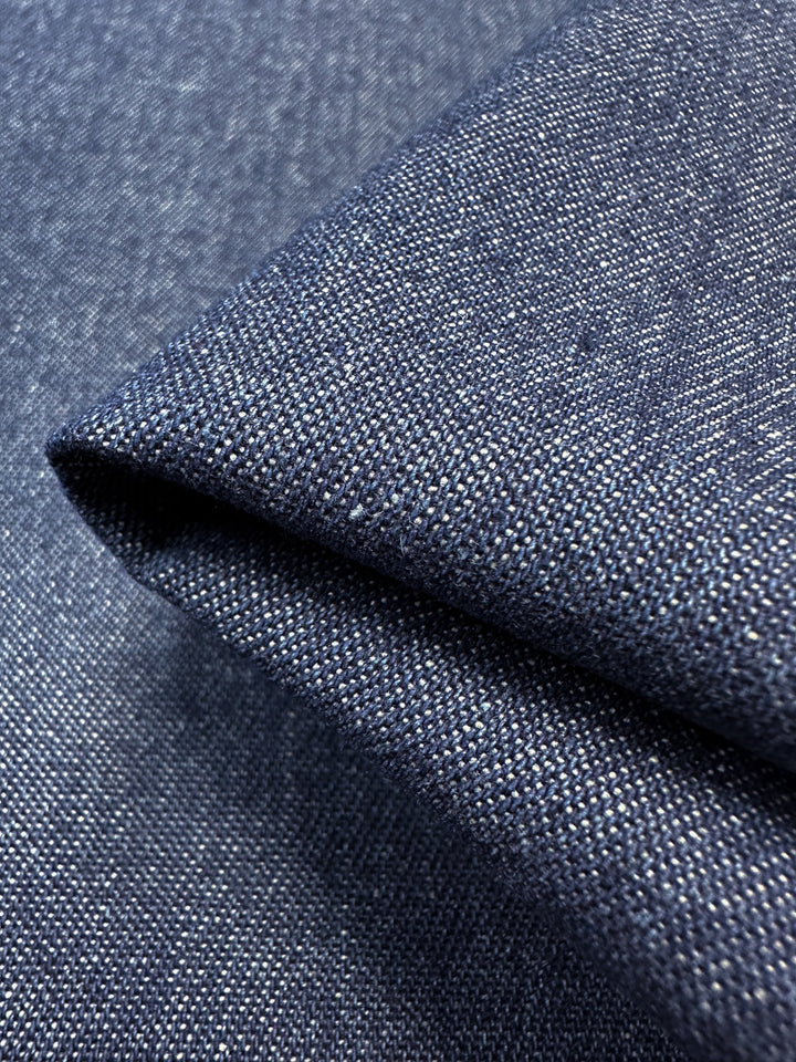 Close-up of folded Denim - Oceana - 150cm from Super Cheap Fabrics, highlighting its textured weave and subtle color variations, crafted from 100% cotton.