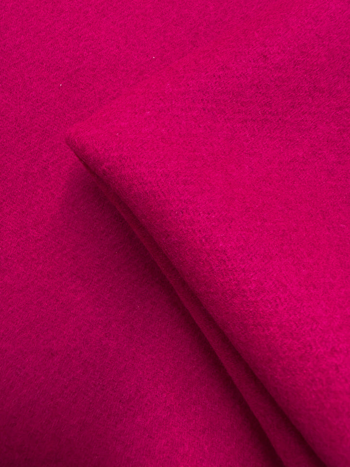 A close-up of the vibrant pink Wool Cashmere - Vivacious - 148cm by Super Cheap Fabrics highlights its soft, felt-like texture and premium quality.