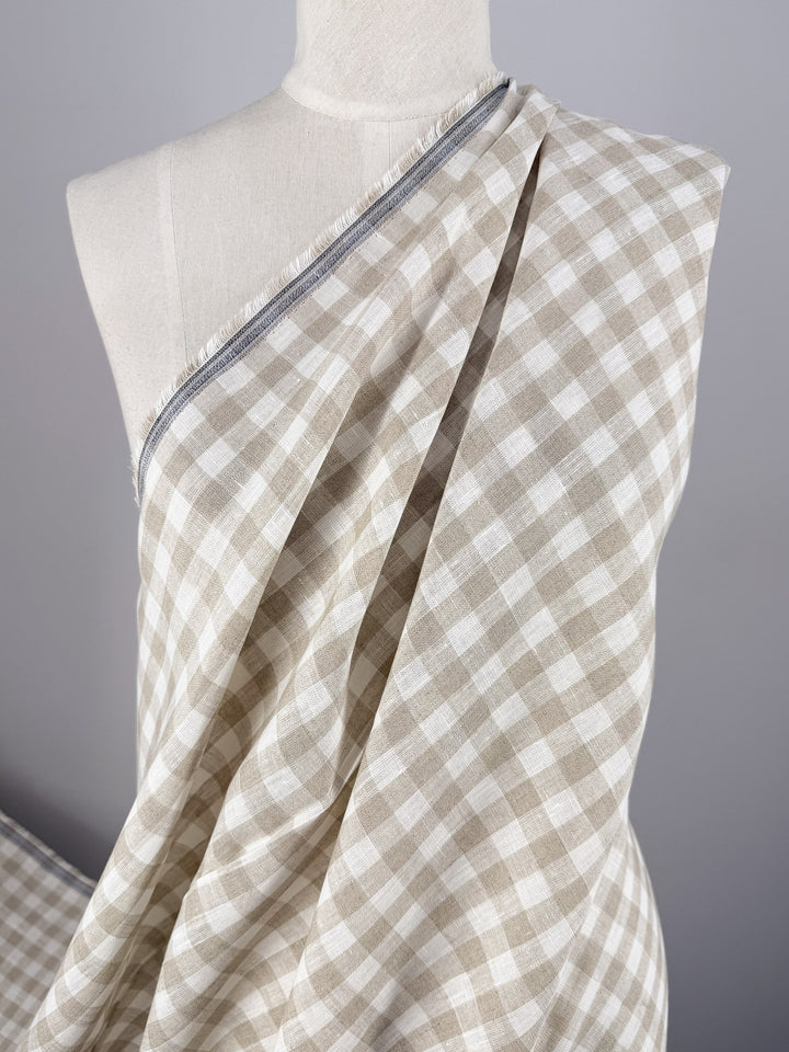 A mannequin displays Super Cheap Fabrics’ Pure Linen - Oatfield Check (140cm), featuring beige and white gingham checks in a soft, lightweight fabric, set against a neutral background.