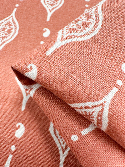 A close-up of Super Cheap Fabrics' Linen Blend - Repeater fabric, featuring a pink background with white leaf-like patterns and a woven texture that offers a soft, durable feel. Perfect for charming children's clothing designs. Width: 130cm.