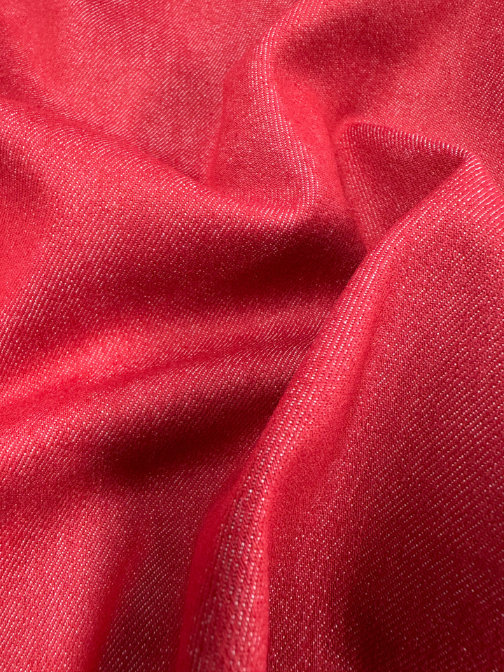 Close-up of Super Cheap Fabrics' Stretch Denim - Toreador, 145cm: a soft, red fabric with a smooth texture and subtle sheen, reminiscent of the gentle folds and drapes found in premium denims.