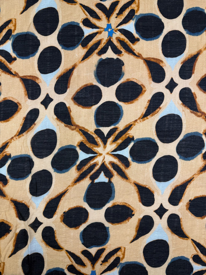 Textured Designer Cotton - Terra Dot by Super Cheap Fabrics features large black spots, brown outlines, and blue accents on beige in a bold geometric pattern—ideal for modern quilting or lightweight cotton projects. Width: 145cm.