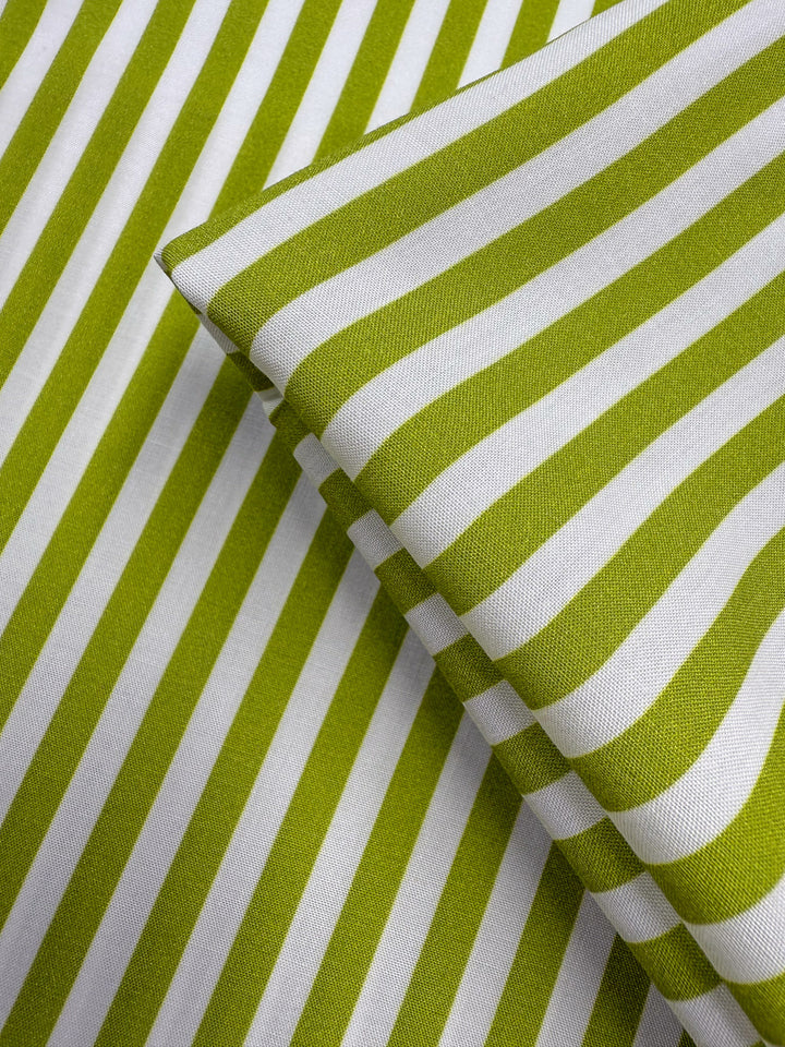 Super Cheap Fabrics' Printed Rayon - Lime Pop Stripe (140cm) features green and white diagonal stripes in a bold, modern pattern. This lightweight fabric is perfect for crisp, contemporary designs.