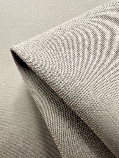 Close-up of Super Cheap Fabrics' Cotton Lycra - Tuffet (170cm), displaying its detailed texture and visible tight knit. Smoothly draped and stretchy, it's perfect for soft, natural folds in bodycon dresses.