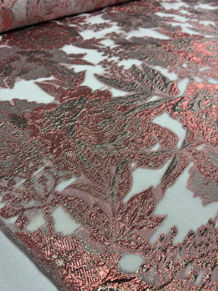 Close-up of the Designer Metallic Brocade - Anne by Super Cheap Fabrics, a lightweight fabric with a detailed rose gold floral pattern. The intricate design features various flowers and leaves woven into a multi-coloured sheer, light-colored background, creating an elegant and textured surface reminiscent of Turkey’s rich textile heritage. The fabric measures 160cm in width.