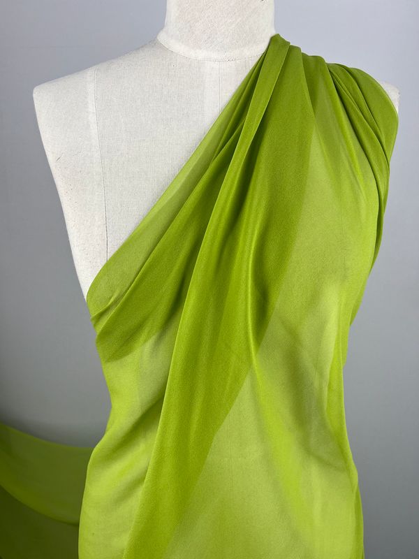 A mannequin draped in Super Cheap Fabrics' Silk Georgette - Evergreen - 135cm. The lightweight fabric is arranged asymmetrically, covering one shoulder while leaving the other exposed, creating smooth, flowing folds that accentuate its softness and sheen—perfect for spring summer.