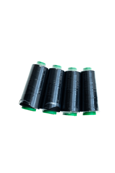 Four black 4 Pack Overlocking Thread - Black from Super Cheap Fabrics, each capped with a green top and bottom, stand upright against a white background. The 4-pack of threads is neatly lined up side by side.