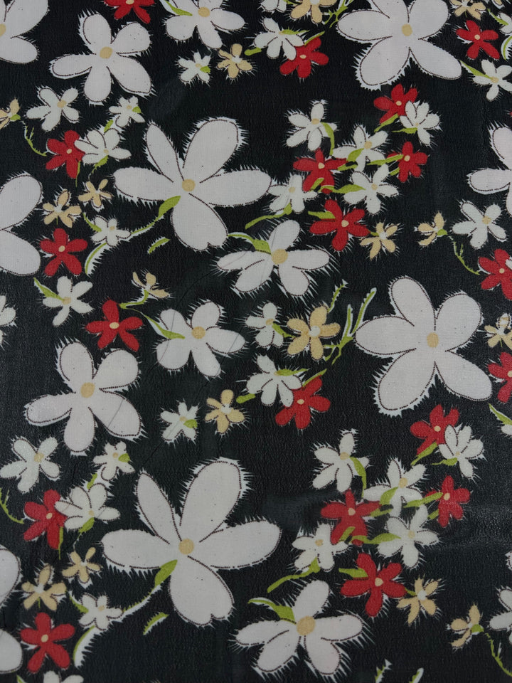 A vibrant design, featuring a floral pattern with white and red painted flowers accompanied by green stems and leaves set against a dark backdrop, the "Printed Georgette - Jasmine Cluster - 150cm" from Super Cheap Fabrics showcases a range of flower sizes. This lively and colorful pattern is perfect for sheer polyester or Georgette fabric.