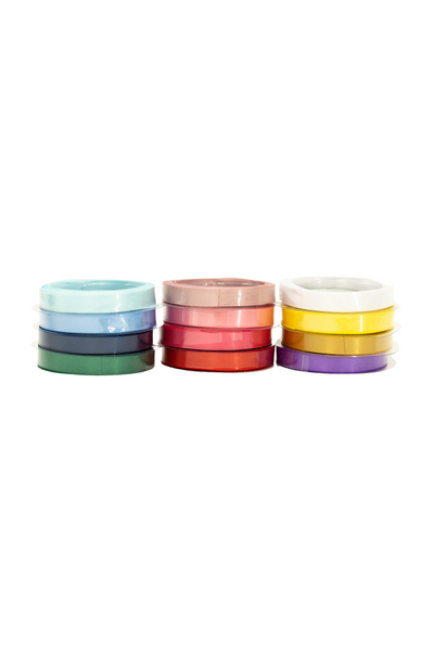 A stack of colorful adhesive tapes arranged in three separate piles, resembling vibrant ribbons. The tapes' colors include shades of blue, green, pink, red, yellow, and purple. They are set against a white background. This is the Ribbon - 12 Colours from Super Cheap Fabrics.